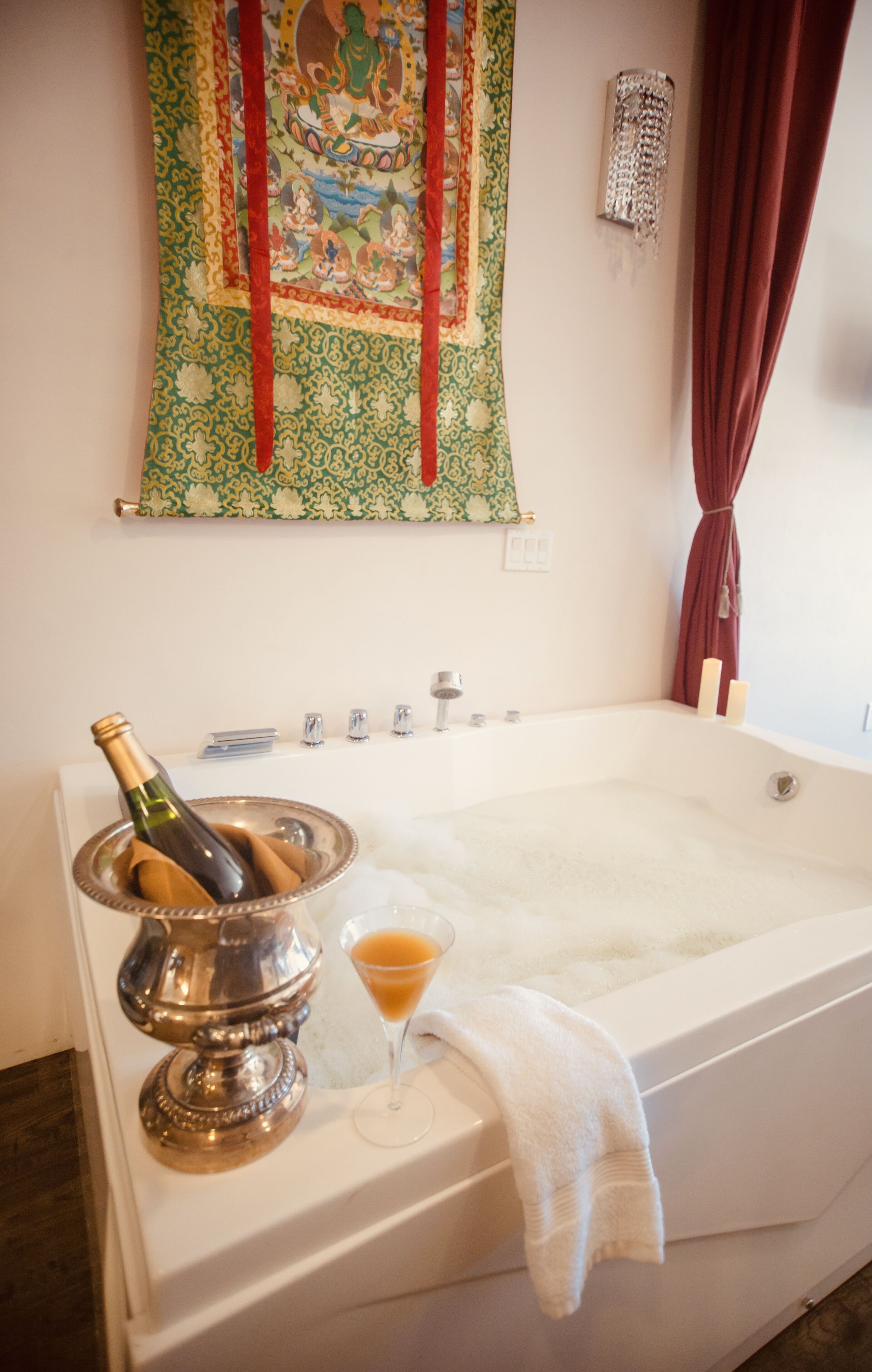 Une salle de bain avec une baignoire, une bouteille de champagne et un verre de champagne.
