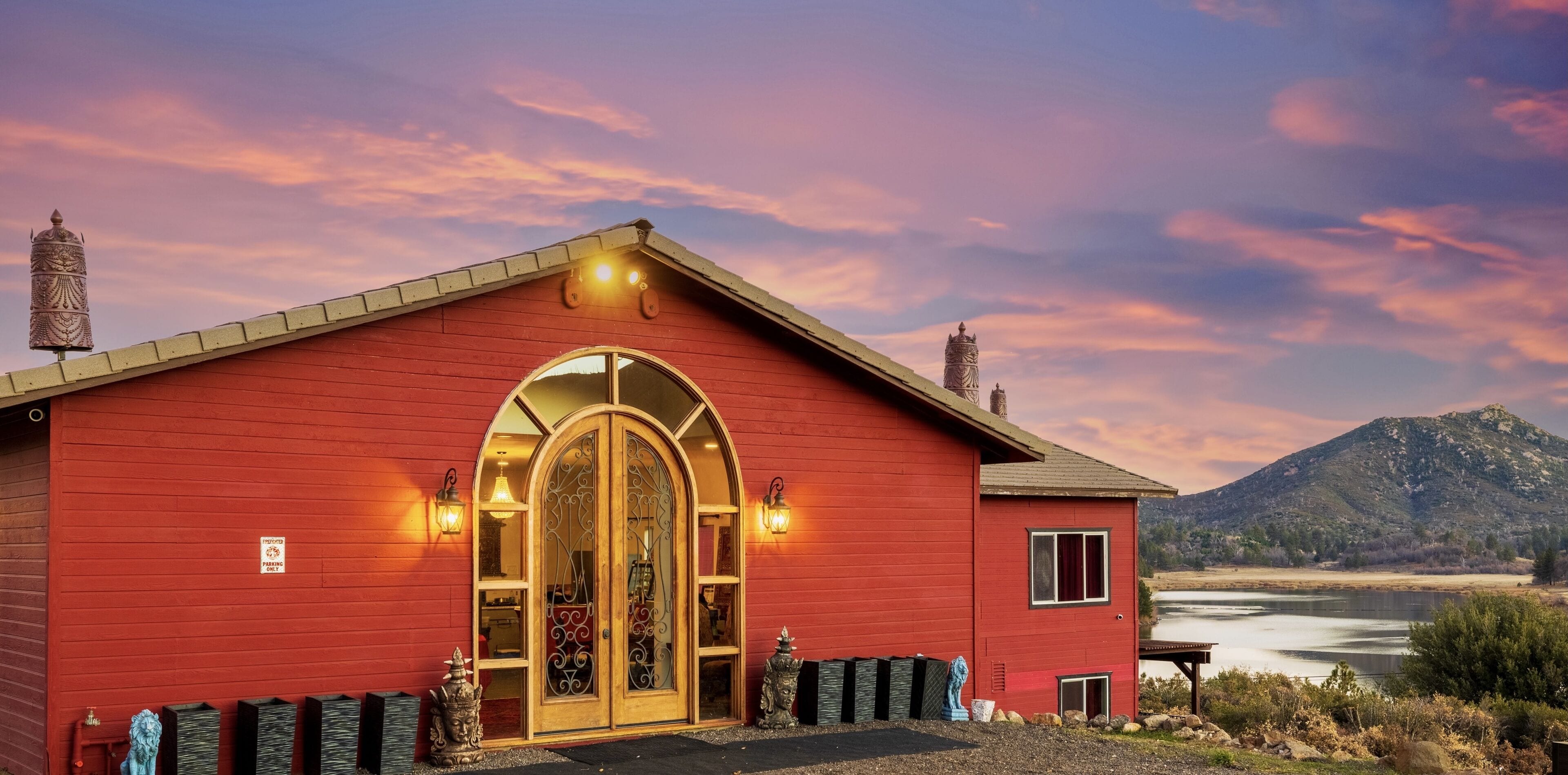 Un edificio rojo con una gran entrada en arco, una ventana pequeña y un letrero que indica un descuento del 50%.