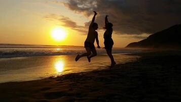 On the beach, black sand, beach umbrellas, beach volleyball