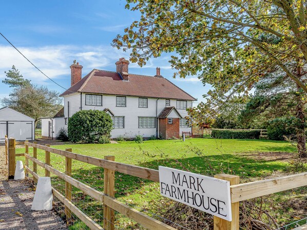 A farmhouse with a sign reading "MARK FARMHOUSE."