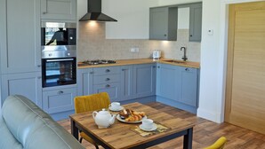 Una cucina moderna con mobili grigi, forno integrato, piano cottura a gas e lavello.