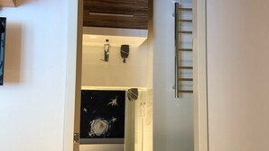 Un baño con un espejo grande, un mueble de madera, ducha e inodoro.