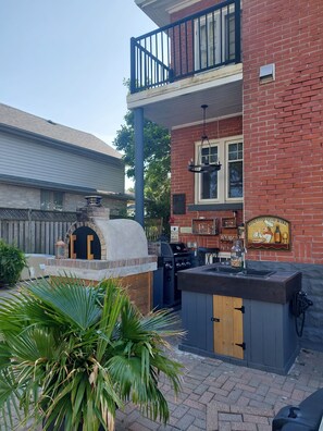 A barbecue area with a brick oven, grill, and a sign that reads "GOOD FOOD GOOD WINE". - Nicklin House (Leamington)