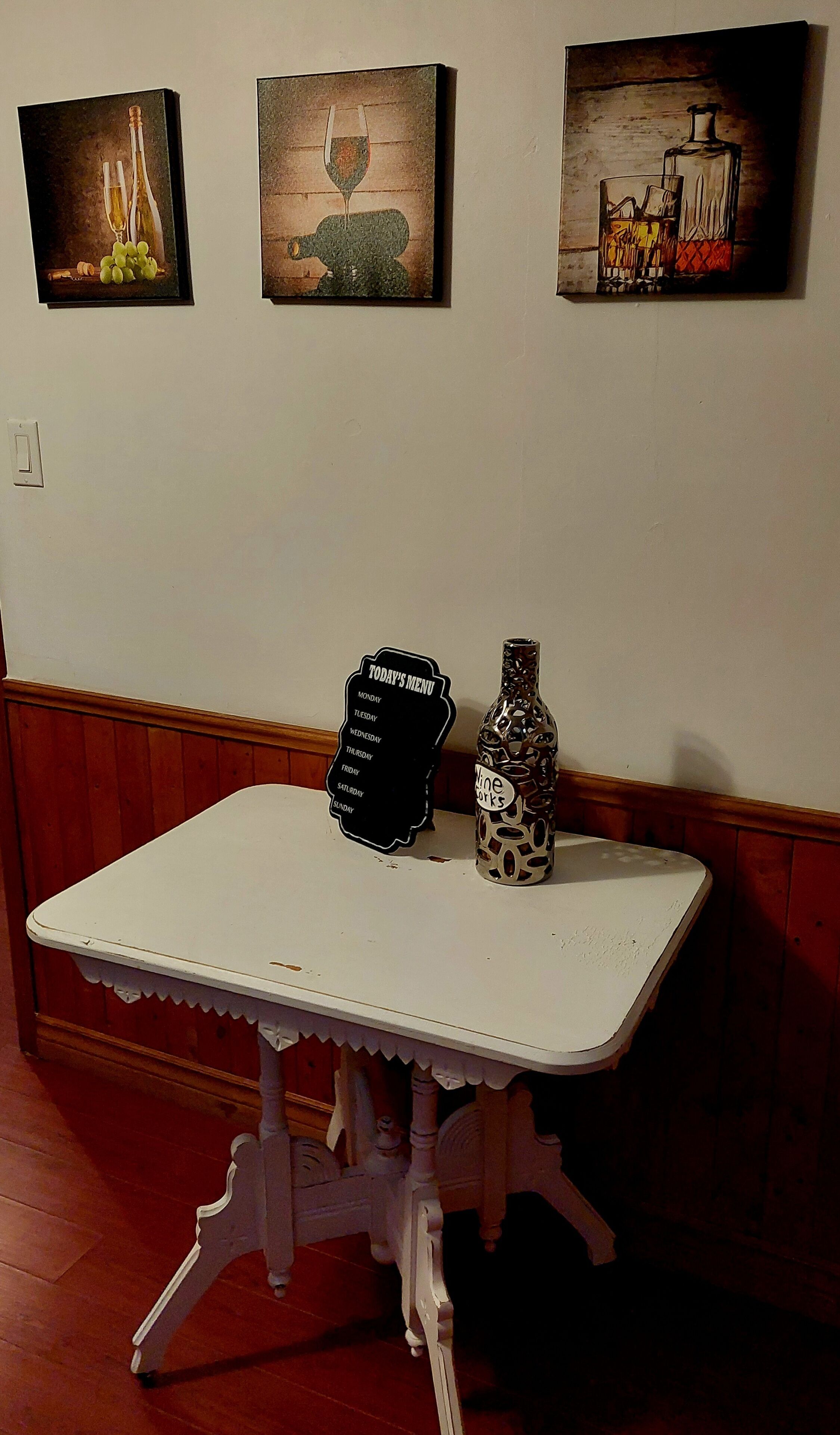 A table with a menu sign and a decorative bottle.