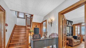 A wooden staircase, a coffee bar, and a living area with a sofa and a fireplace. - Nicklin House (Leamington)