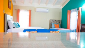 A hotel room with two beds, a ceiling fan, an air conditioning unit, and a view of the outdoors. - Drax Hall Manor Country Club Studio (Ocho Rios)