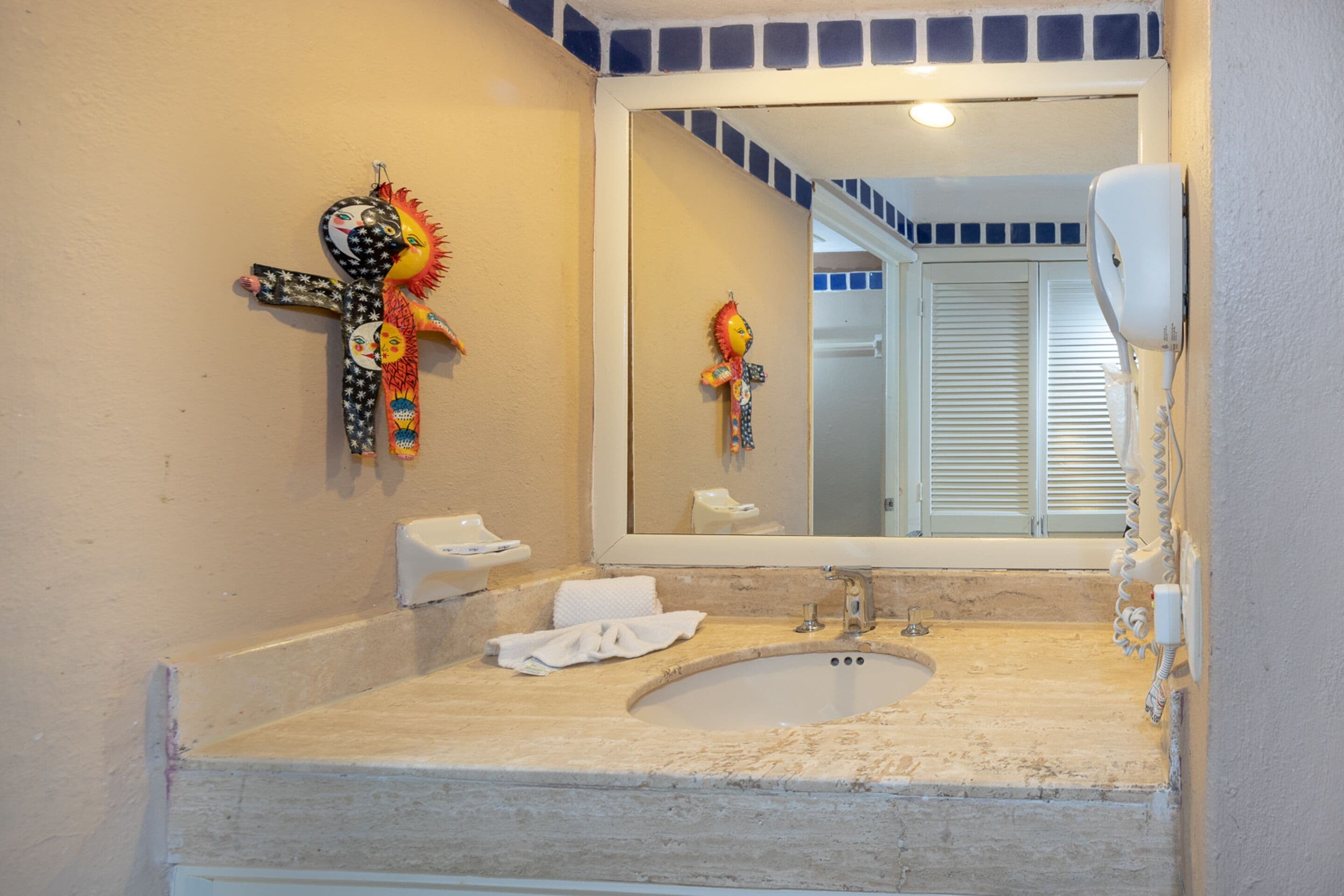 A bathroom with a sink, mirror, and decorative items.