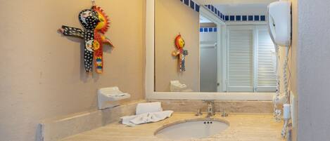 A bathroom with a sink, mirror, and decorative items.