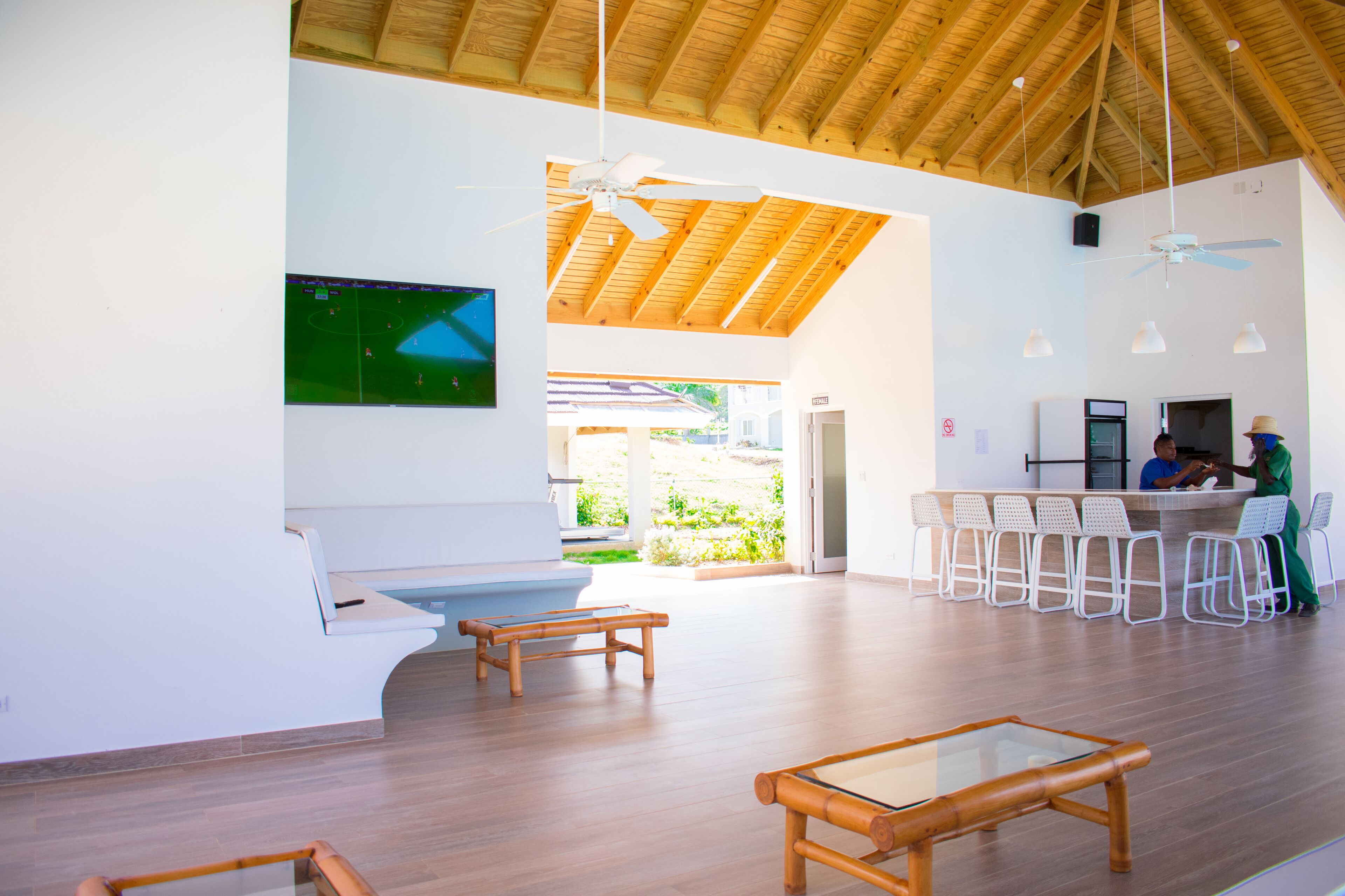 A spacious indoor area with a high ceiling, wooden flooring, and a seating area with a table.