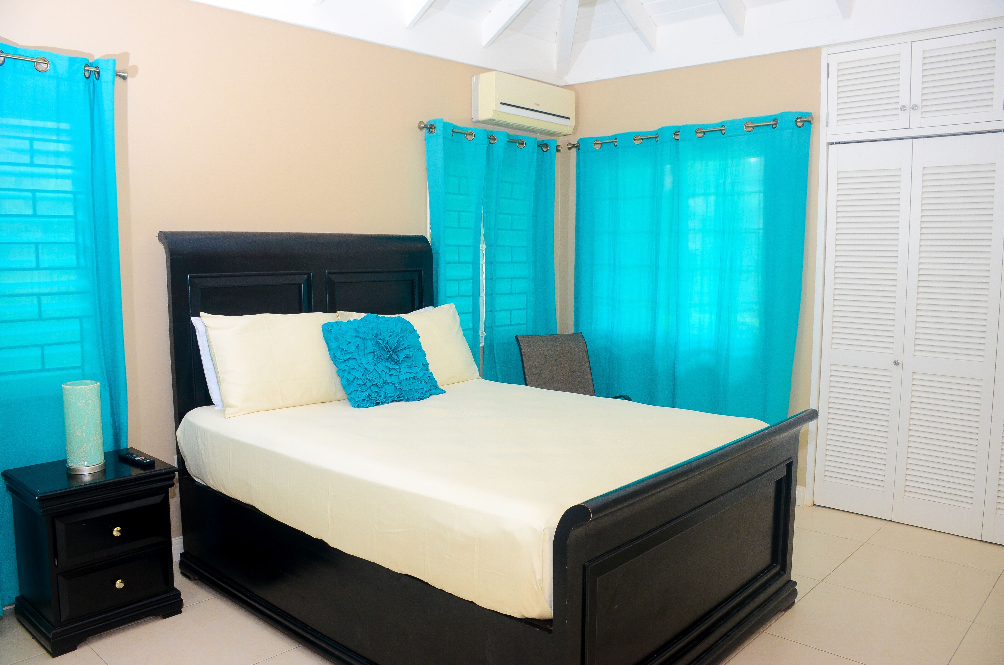 Une chambre à coucher avec un lit, une table de chevet et une armoire.