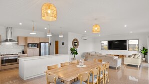 Una cocina moderna con armarios blancos, una isla central e iluminación colgante.