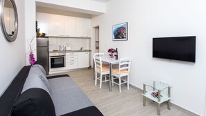A modern apartment with a living area, kitchenette, and dining space. - Apartments L&M - One Bedroom Apartment with Terrace (Dubrovnik)