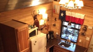 Una cocina compacta con armarios de madera, un refrigerador, un lavamanos y un ventanal con vistas.