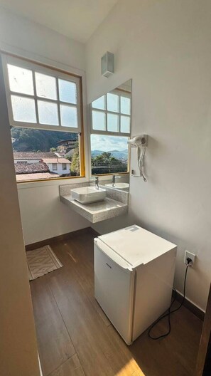 A bathroom with a window, two sinks, a mirror, and a white cabinet. - Pousada Imperial Cidade (Ouro Preto)