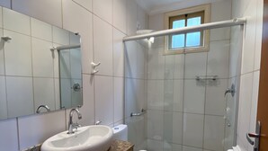 A bathroom with a granite countertop, white sink, and a glass-enclosed shower area. - Pousada Imperial Cidade (Ouro Preto)