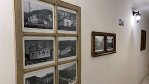 A hallway with framed black and white photographs of historical buildings and landmarks. - Pousada Imperial Cidade (Ouro Preto)