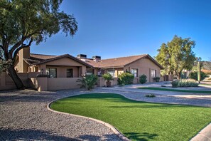 A residential property with a well-maintained lawn, a gravel driveway, and a tiled roof.