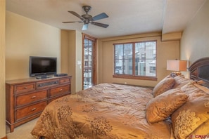 Relax in comfort with a large bed, flat-screen TV, and ceiling fan.