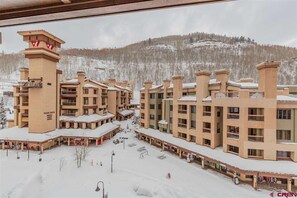 Hotel stands tall amidst a serene winter landscape, its central tower bearing a distinctive emblem.