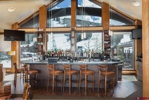 Enjoy a drink with a mountain view at this bar, featuring a selection of beverages and comfortable seating.