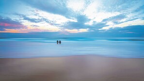 A beach with two people walking towards the horizon. - Duke St Convenience at your doorstep! Beach living (SUNSHINE BEACH)