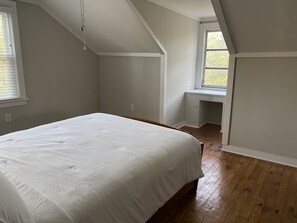 Une chambre à coucher avec un lit, un bureau et une fenêtre.