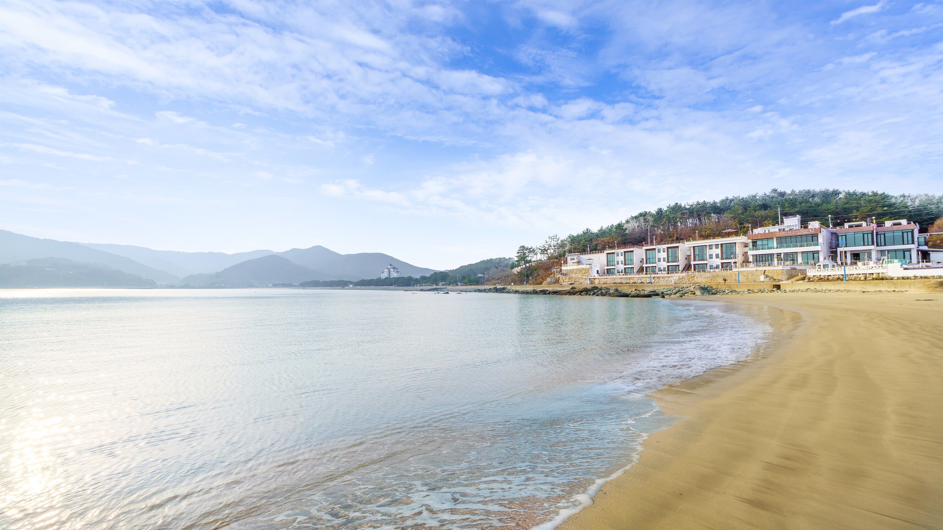 Un hotel frente al mar con una playa de arena.