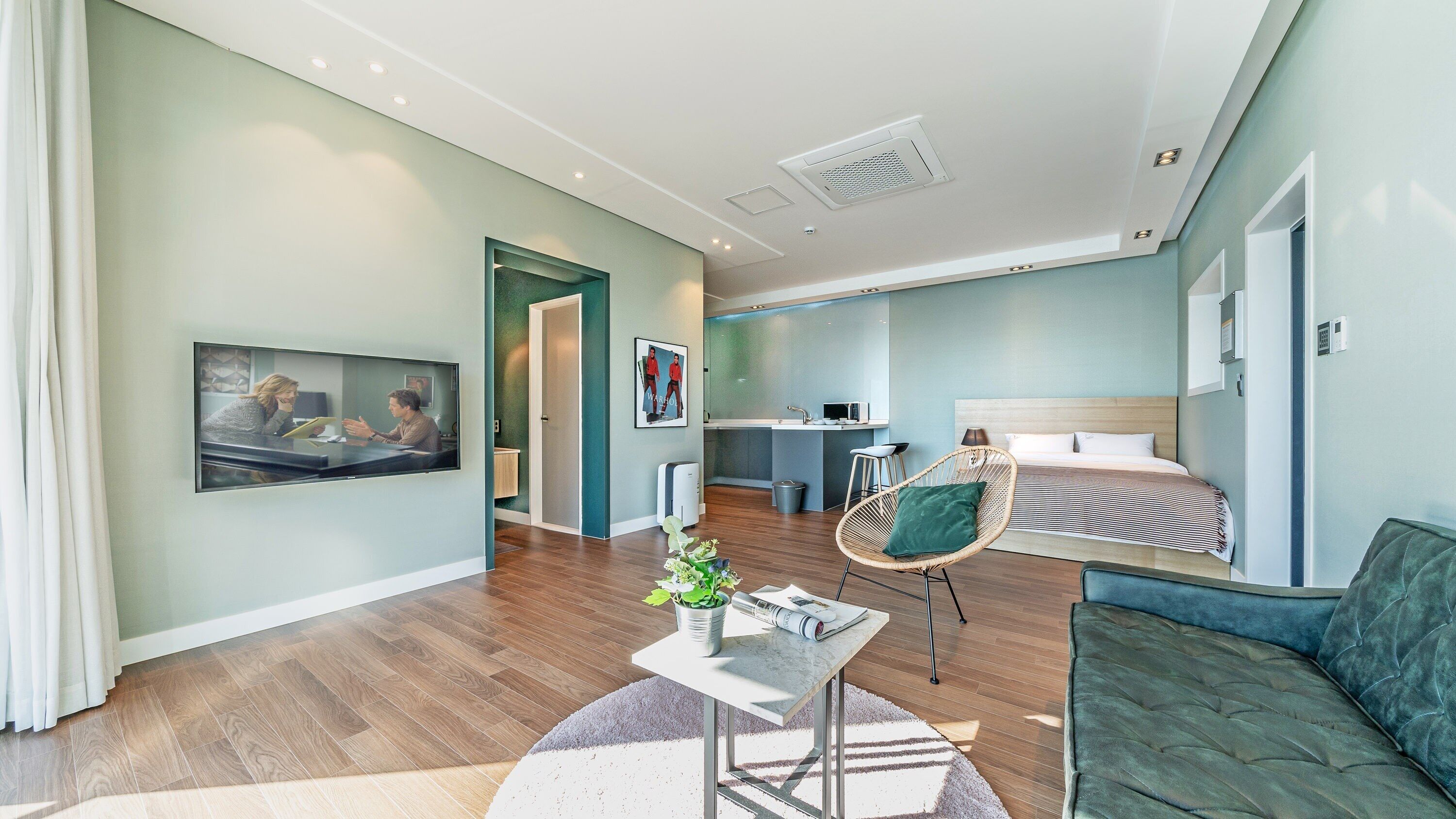 Une chambre d’hôtel moderne équipée d’un lit, d’un canapé, d’un coin repas et d’une cuisine.