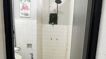 Une salle de bain avec des toilettes, une douche et un lavabo.