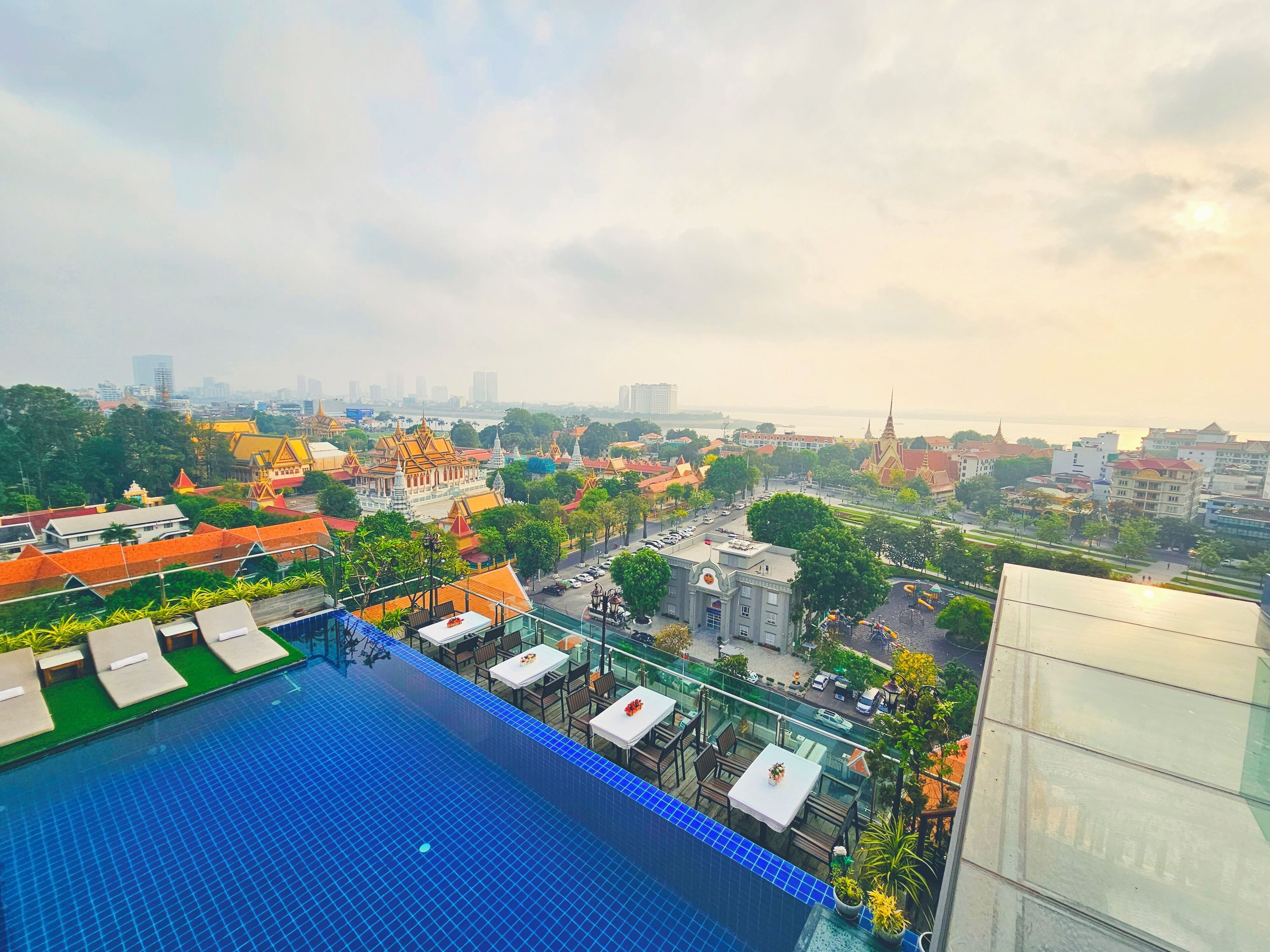 A rooftop pool with a view of a cityscape, including traditional buildings and modern high-rises.