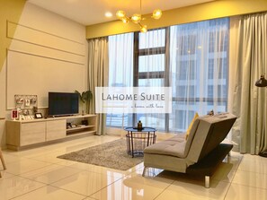 A modern living room with a sofa, TV, and a coffee table. - The Robertson KL By Lahome Suite (Kuala Lumpur)