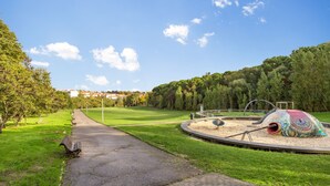 A park with a winding path, a colorful spiral sculpture, and a playground. - Stupendo Airport Studio 1 (Lisboa)