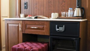 Uma cozinha compacta com armários de madeira, forno embutido, cafeteira e um pequeno espaço com assentos.