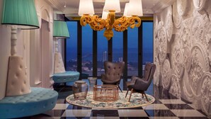 A luxurious room with a chandelier, plush seating, and ornate wall decorations. - Arte S Family Suites (George Town)