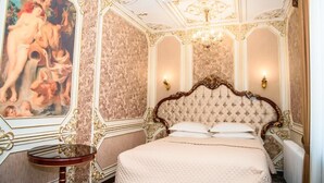 Une chambre à coucher luxueuse, avec un lit somptueux, un grand tableau au mur et un plafond décoratif.