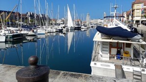A marina with multiple boats docked, a clear blue sky, and buildings in the background. - Apartment Le Hoc by Interhome (Deauville-Trouville)