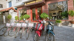 A hotel entrance with a sign reading "Diamond Hotel," a row of bicycles, and several potted plants. - Diamond Hotel (Ninh Binh)