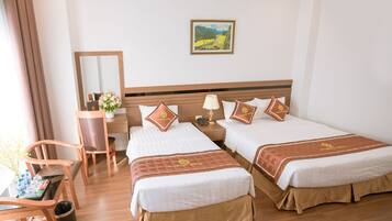 Quarto de hotel com duas camas, uma escrivaninha, uma cadeira e um espelho.