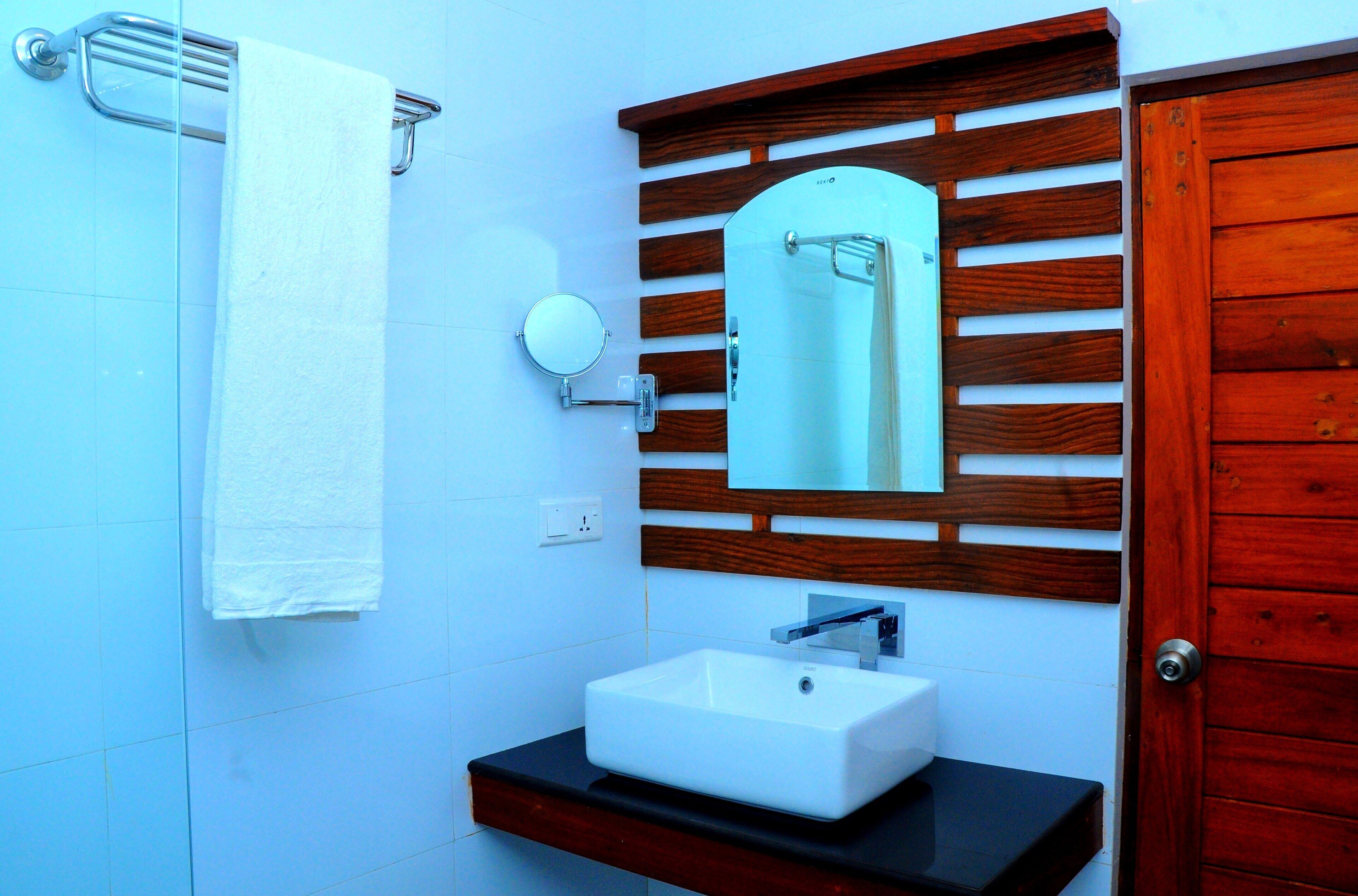 A bathroom with a white sink, a mirror, and a towel rack.