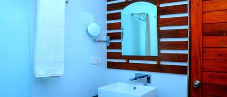 A bathroom with a white sink, a mirror, and a towel rack.