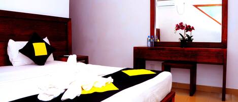 A neatly made bed with a black and yellow bedspread, a wooden headboard, and a bedside table with a mirror.