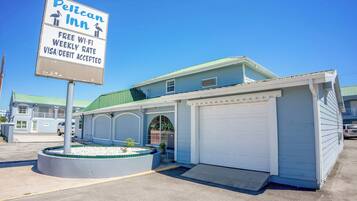 Un motel avec une enseigne indiquant que le Wi-Fi est gratuit, qu’il propose des tarifs hebdomadaires et qu’il accepte les cartes Visa et de débit.