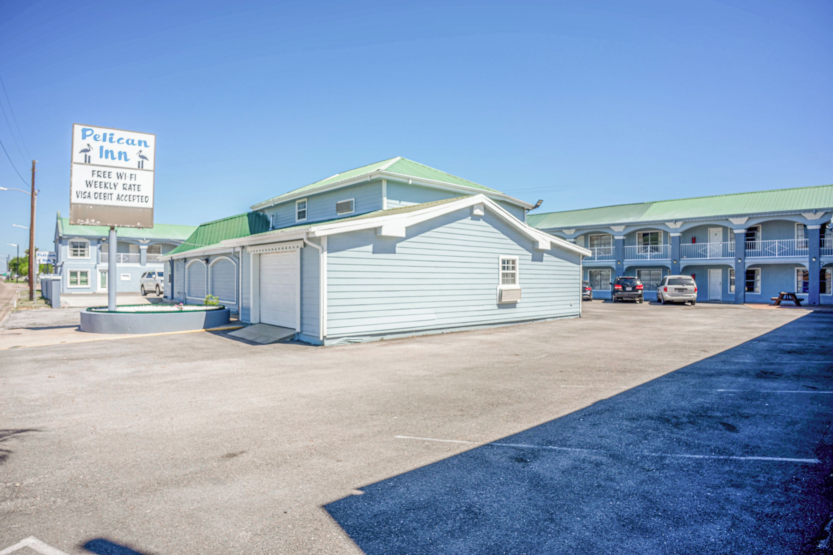 A motel with a sign advertising free Wi-Fi, weekly rate, and Visa debit card acceptance.