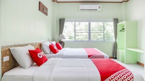 A hotel room with two beds, a window with curtains, an air conditioning unit, and a green wardrobe. - OYO 742 View Pruksa Resort (Ranong)