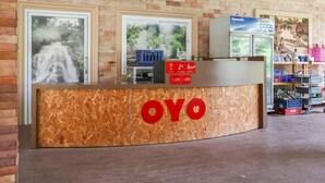 A reception desk with the name "OYO" prominently displayed, a Panasonic refrigerator, and a Coca-Cola crate in the background. - OYO 742 View Pruksa Resort (Ranong)