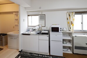 A compact kitchen with a sink, microwave, and refrigerator.