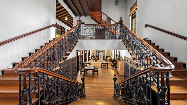 A grand staircase with ornate black railings and wooden steps leading to a second floor. - The Postcard Galle (Galle)
