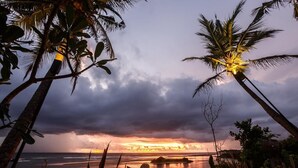 A sunset view with palm trees and a bridge over water. - The Postcard Galle (Galle)