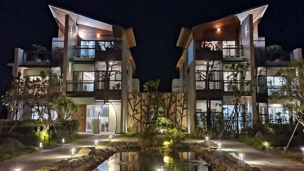 A modern building with a symmetrical facade, large windows, and a central courtyard with a water feature. - Gala Villa (Hengchun)