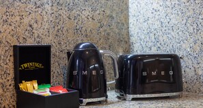 A kitchen with a granite countertop, a black coffee maker, a toaster, and a box of Twinings tea.